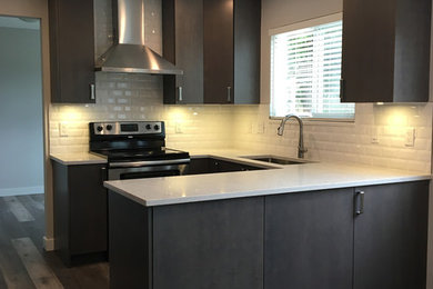 Example of a mid-sized classic u-shaped medium tone wood floor and brown floor enclosed kitchen design in Other with an undermount sink, shaker cabinets, brown cabinets, white backsplash, stainless steel appliances, no island and white countertops