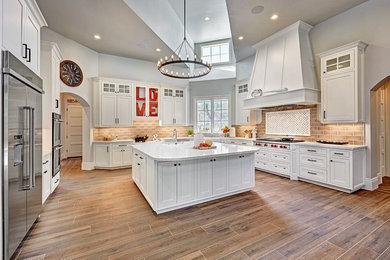 Large elegant brown floor enclosed kitchen photo in Sacramento with shaker cabinets, white cabinets, marble countertops, brown backsplash, stainless steel appliances and an island