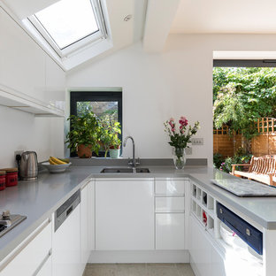 Small contemporary u-shaped open plan kitchen in London with a submerged sink, flat-panel cabinets, white cabinets, composite countertops, stainless steel appliances, porcelain flooring, beige floors, grey worktops and a breakfast bar.