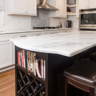 Photo of a large u-shaped eat-in kitchen in New York with an undermount sink, flat-panel cabinets, white cabinets, quartzite benchtops, white splashback, porcelain splashback, stainless steel appliances, plywood floors and with island.