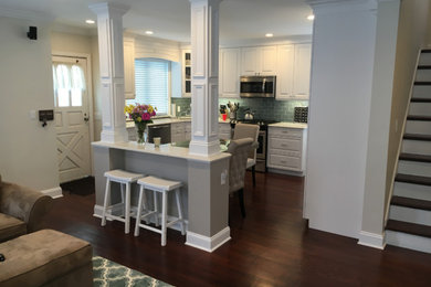 Exempel på ett mellanstort klassiskt kök, med en undermonterad diskho, luckor med upphöjd panel, vita skåp, marmorbänkskiva, grönt stänkskydd, stänkskydd i tunnelbanekakel, rostfria vitvaror, mörkt trägolv, en köksö och brunt golv