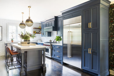 Kitchen - transitional l-shaped dark wood floor and brown floor kitchen idea in New York with blue cabinets, quartzite countertops, white backsplash, stainless steel appliances, an island, shaker cabinets, subway tile backsplash and white countertops