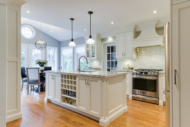 Kitchen - large transitional medium tone wood floor kitchen idea in Toronto with an undermount sink, recessed-panel cabinets, granite countertops, white backsplash, marble backsplash, stainless steel appliances and an island