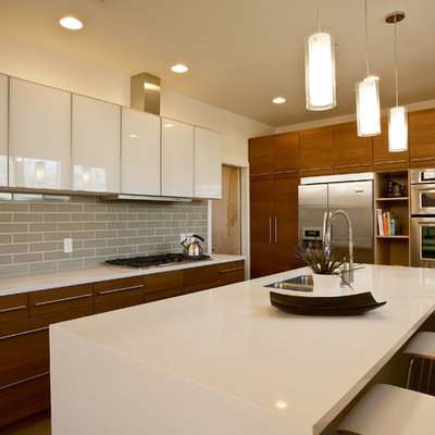 Mid-sized trendy u-shaped open concept kitchen photo in Austin with subway tile backsplash, stainless steel appliances, flat-panel cabinets, white cabinets, gray backsplash, a double-bowl sink, solid surface countertops and an island