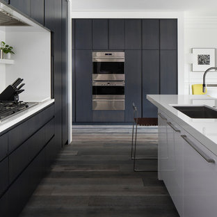 Esempio di una cucina minimal di medie dimensioni con ante lisce, lavello sottopiano, ante nere, top in quarzite, elettrodomestici da incasso, pavimento in legno massello medio e pavimento grigio