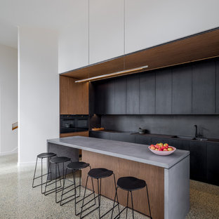 Photo of a modern l-shaped kitchen in Canberra - Queanbeyan with flat-panel cabinets, black cabinets, with island, grey floor and grey benchtop.