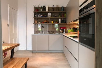 Design ideas for a small contemporary l-shaped kitchen/diner in Edinburgh with an integrated sink, flat-panel cabinets, grey cabinets, engineered stone countertops, brown splashback, wood splashback, integrated appliances, vinyl flooring, no island and grey floors.