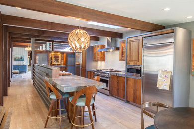 Mid-sized mid-century modern galley light wood floor and gray floor kitchen photo in Denver with a double-bowl sink, flat-panel cabinets, medium tone wood cabinets, blue backsplash, cement tile backsplash, stainless steel appliances, quartzite countertops and gray countertops