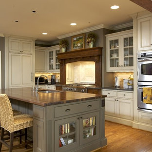 Traditional kitchen remodeling - Kitchen - traditional kitchen idea in Birmingham with beaded inset cabinets, paneled appliances, wood countertops, beige cabinets and brown countertops