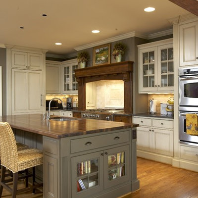 Kitchen - traditional kitchen idea in Birmingham with beaded inset cabinets, paneled appliances, wood countertops, beige cabinets and brown countertops