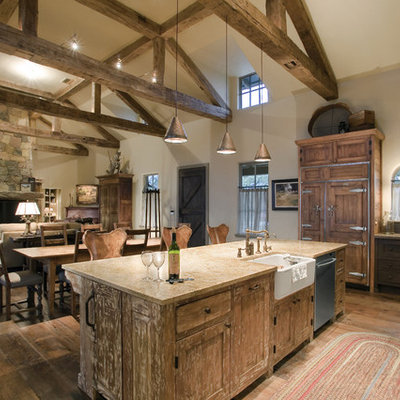Inspiration for a large rustic l-shaped open concept kitchen remodel in Austin with granite countertops, a farmhouse sink, distressed cabinets, paneled appliances and an island