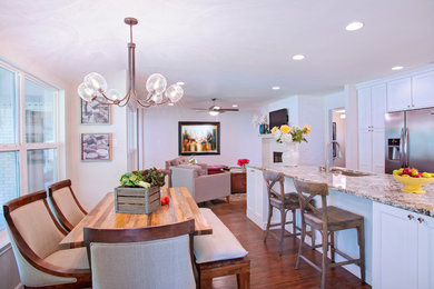 Example of a mid-sized transitional u-shaped medium tone wood floor eat-in kitchen design in Austin with a single-bowl sink, shaker cabinets, white cabinets, granite countertops, white backsplash, subway tile backsplash, stainless steel appliances and a peninsula