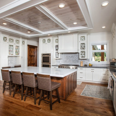 Inspiration for a transitional u-shaped dark wood floor and brown floor kitchen remodel in Other with an undermount sink, raised-panel cabinets, white cabinets, gray backsplash, stainless steel appliances, an island and gray countertops