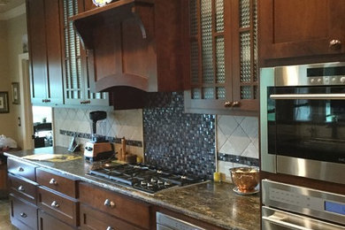 Mid-sized elegant kitchen photo in Austin with shaker cabinets, dark wood cabinets, multicolored backsplash, mosaic tile backsplash, stainless steel appliances and an island
