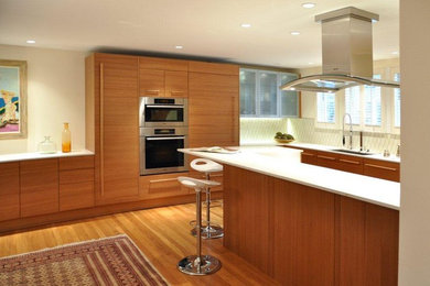 Modern inredning av ett mellanstort vit vitt kök, med en undermonterad diskho, släta luckor, skåp i ljust trä, bänkskiva i kvarts, vitt stänkskydd, stänkskydd i keramik, rostfria vitvaror, ljust trägolv, en köksö och gult golv