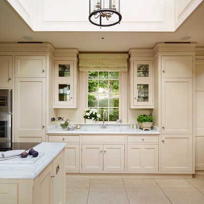 Eat-in kitchen - large traditional eat-in kitchen idea in London with beaded inset cabinets, marble countertops, gray backsplash, stainless steel appliances and an island