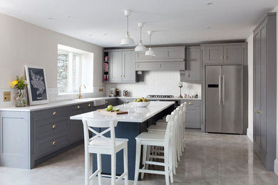 Design ideas for a medium sized classic l-shaped kitchen/diner in Other with shaker cabinets, grey cabinets, quartz worktops, white splashback, ceramic splashback, concrete flooring, an island, grey floors and white worktops.