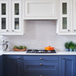 Photo of a classic u-shaped kitchen/diner in Other with beaded cabinets, blue cabinets, white splashback, a breakfast bar, white worktops, quartz worktops and ceramic splashback.