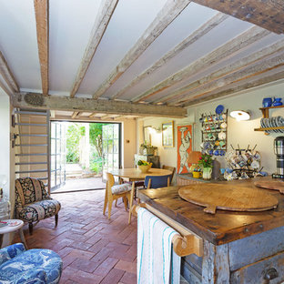 Photo of a medium sized rustic kitchen in Oxfordshire with an island and red floors.