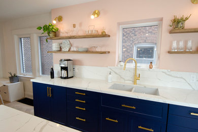 Example of a mid-sized trendy galley medium tone wood floor and beige floor open concept kitchen design in Toronto with an undermount sink, shaker cabinets, blue cabinets, white backsplash, marble backsplash, black appliances, an island, white countertops and quartz countertops