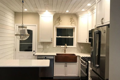 Mid-sized cottage l-shaped dark wood floor and brown floor eat-in kitchen photo in Philadelphia with a farmhouse sink, beaded inset cabinets, yellow cabinets, quartz countertops, metallic backsplash, glass tile backsplash, stainless steel appliances, an island and white countertops