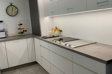 Offene, Große Moderne Küche ohne Insel in L-Form mit Kassettenfronten, weißen Schränken, Küchenrückwand in Weiß und grauer Arbeitsplatte