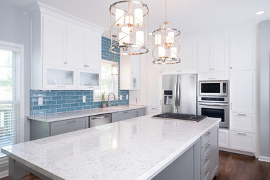 Open concept kitchen - mid-sized transitional l-shaped dark wood floor open concept kitchen idea in Atlanta with a single-bowl sink, shaker cabinets, white cabinets, quartzite countertops, blue backsplash, subway tile backsplash, stainless steel appliances and an island