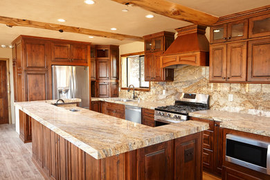 Large mountain style l-shaped ceramic tile and brown floor eat-in kitchen photo in Other with an undermount sink, raised-panel cabinets, medium tone wood cabinets, granite countertops, multicolored backsplash, stone slab backsplash, stainless steel appliances and an island