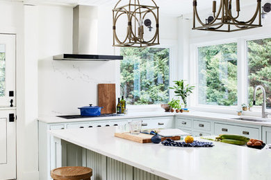 This is an example of a coastal l-shaped kitchen in DC Metro with a submerged sink, shaker cabinets, grey cabinets, white splashback, stone slab splashback, an island, grey floors and white worktops.