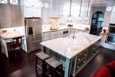 Enclosed kitchen - large transitional u-shaped dark wood floor and brown floor enclosed kitchen idea in Miami with a farmhouse sink, recessed-panel cabinets, white cabinets, quartzite countertops, multicolored backsplash, matchstick tile backsplash, stainless steel appliances, an island and white countertops