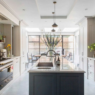 Design ideas for a medium sized classic galley kitchen in London with a submerged sink, recessed-panel cabinets, beige cabinets, marble worktops, beige splashback, stainless steel appliances, concrete flooring, an island, grey floors and grey worktops.