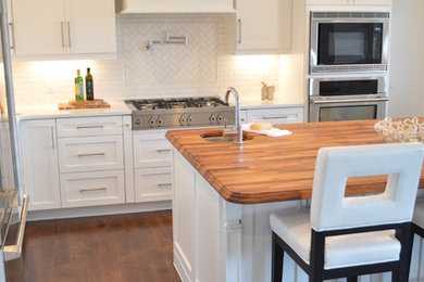Large arts and crafts l-shaped dark wood floor kitchen photo in Raleigh with shaker cabinets, white cabinets, white backsplash, stainless steel appliances and an island
