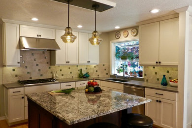 Example of a large arts and crafts u-shaped medium tone wood floor eat-in kitchen design in Portland with an undermount sink, shaker cabinets, white cabinets, granite countertops, beige backsplash, porcelain backsplash, stainless steel appliances and an island
