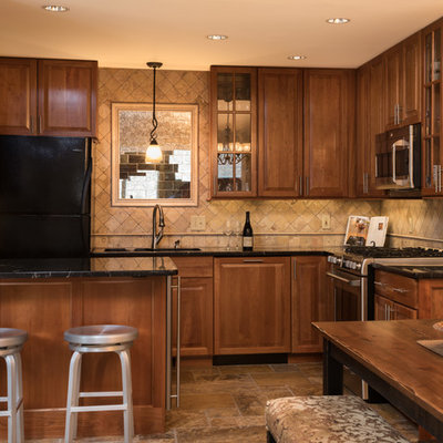 Inspiration for a small craftsman u-shaped terrazzo floor eat-in kitchen remodel in Boston with an undermount sink, raised-panel cabinets, medium tone wood cabinets, granite countertops, beige backsplash, travertine backsplash, stainless steel appliances and a peninsula