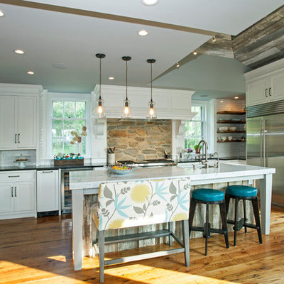 Inspiration for a large farmhouse galley medium tone wood floor open concept kitchen remodel in Philadelphia with white cabinets, white backsplash, stainless steel appliances, an island, a farmhouse sink, flat-panel cabinets and soapstone countertops