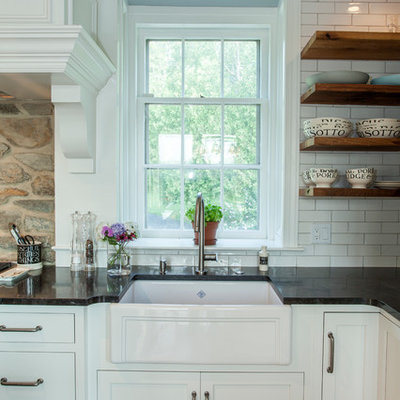Mid-sized cottage l-shaped medium tone wood floor eat-in kitchen photo in Philadelphia with a farmhouse sink, shaker cabinets, white cabinets, marble countertops, white backsplash, subway tile backsplash, stainless steel appliances and an island