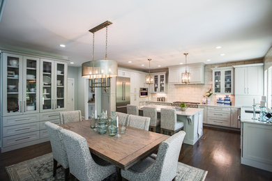 Inspiration for a transitional u-shaped medium tone wood floor and brown floor eat-in kitchen remodel in Charlotte with shaker cabinets, gray cabinets, white backsplash, subway tile backsplash, stainless steel appliances, an island and white countertops