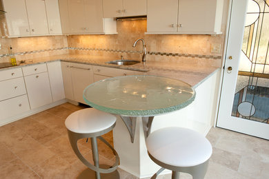 Moderne Küche mit Unterbauwaschbecken, flächenbündigen Schrankfronten, weißen Schränken, Küchenrückwand in Beige und Rückwand aus Mosaikfliesen in Sonstige