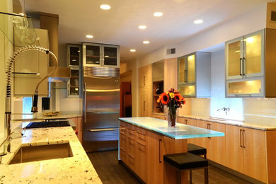 Trendy l-shaped eat-in kitchen photo in New York with an undermount sink, flat-panel cabinets, light wood cabinets, glass countertops, white backsplash, glass tile backsplash and stainless steel appliances