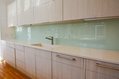 他の地域にある高級な中くらいなコンテンポラリースタイルのおしゃれなキッチン (緑のキッチンパネル、ガラス板のキッチンパネル) の写真
