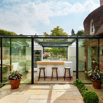 Glass box extension on thatched cottage