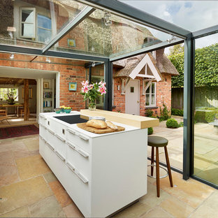 Inspiration for a contemporary kitchen in London with flat-panel cabinets, white cabinets and an island.