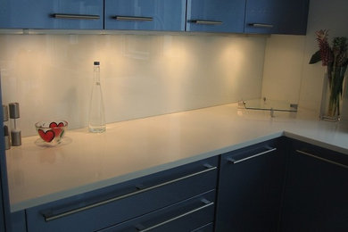 Moderne Küche mit flächenbündigen Schrankfronten, grauen Schränken, Küchenrückwand in Weiß und Rückwand aus Glasfliesen in New York