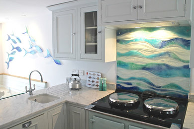 Photo of a contemporary kitchen in Cornwall with glass sheet splashback.