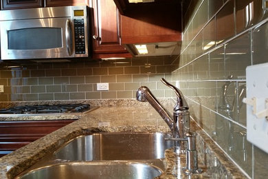 This is an example of a medium sized modern kitchen in Chicago with grey splashback and glass tiled splashback.