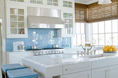 Bild på ett funkis linjärt kök och matrum, med vita skåp, blått stänkskydd, stänkskydd i glaskakel och rostfria vitvaror