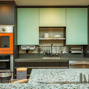 Large contemporary l-shaped open plan kitchen in San Francisco with an undermount sink, flat-panel cabinets, grey cabinets, recycled glass benchtops, coloured appliances, cork floors and with island.