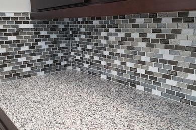 Kitchen - mid-sized transitional kitchen idea in Bridgeport with granite countertops, gray backsplash, glass tile backsplash, shaker cabinets and brown cabinets