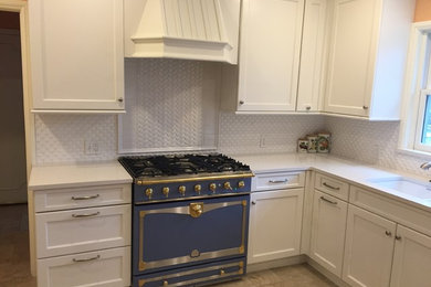 Inspiration for a mid-sized timeless u-shaped ceramic tile enclosed kitchen remodel in Oklahoma City with an undermount sink, recessed-panel cabinets, white cabinets, quartz countertops, white backsplash, porcelain backsplash, colored appliances and a peninsula