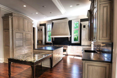 Example of a classic eat-in kitchen design in Chicago with an integrated sink, granite countertops, stone slab backsplash and stainless steel appliances